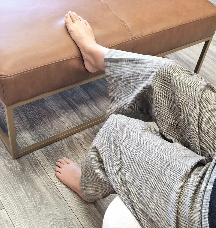 Bare feet resting on an ottoman at the end of a long day on your feet