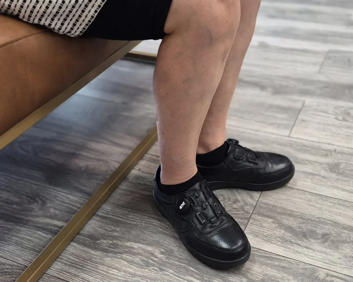 A Tucson customer seated in the JGP USA store wearing stable black leather walking shoes with a secure dial fit