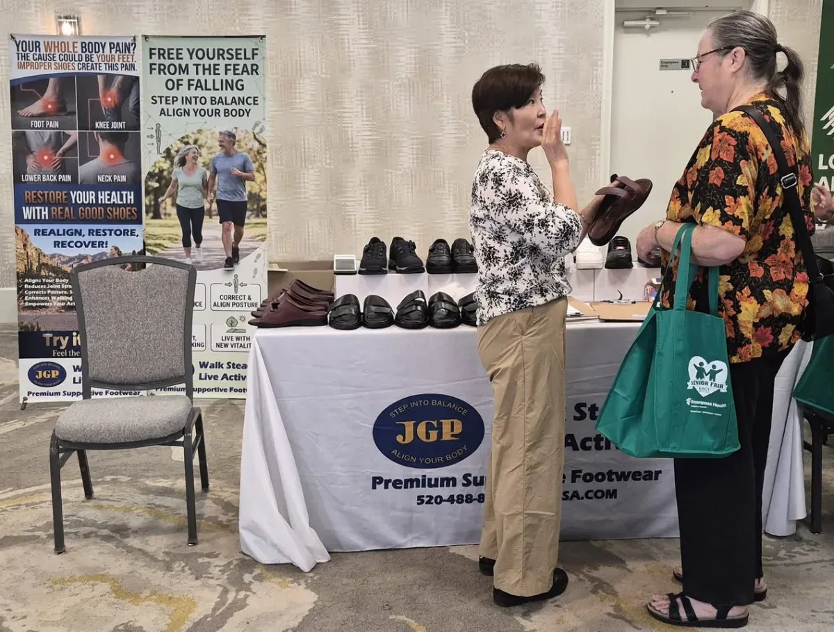 Talking with a visitor about supportive shoes at the JGP USA booth at the KVOA Senior Fair in Tucson